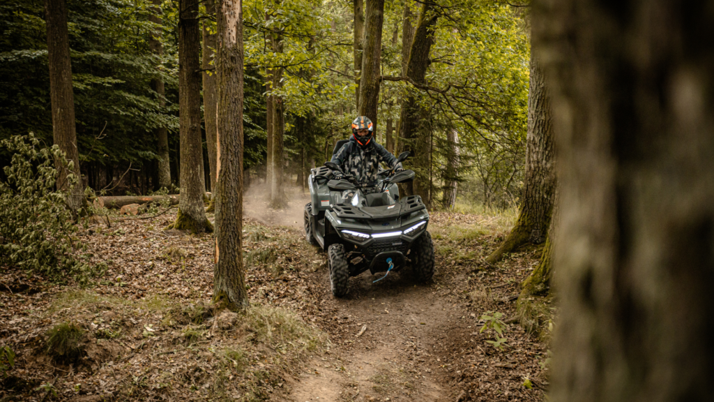 Linhai ATV på skogssti i krevende terreng. Kraftig 4x4 ATV med vinsj og LED-lys brukt til jakt, skogbruk, gårdsarbeid og fritidskjøring. Leveres av Senteret AS i Egersund.